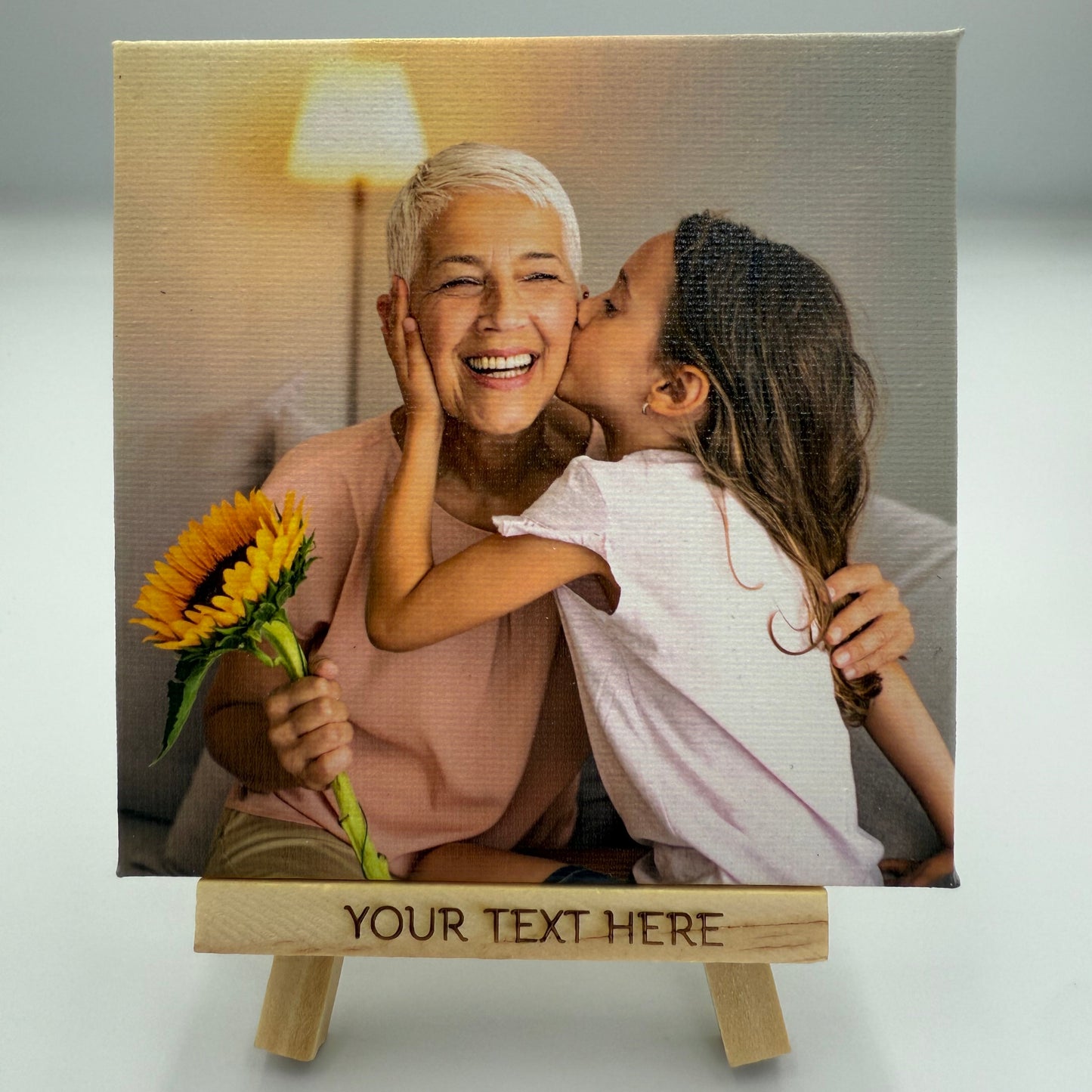 Canvas print of a grandmother and neice with a sunflower, customizable text on a wooden frame.