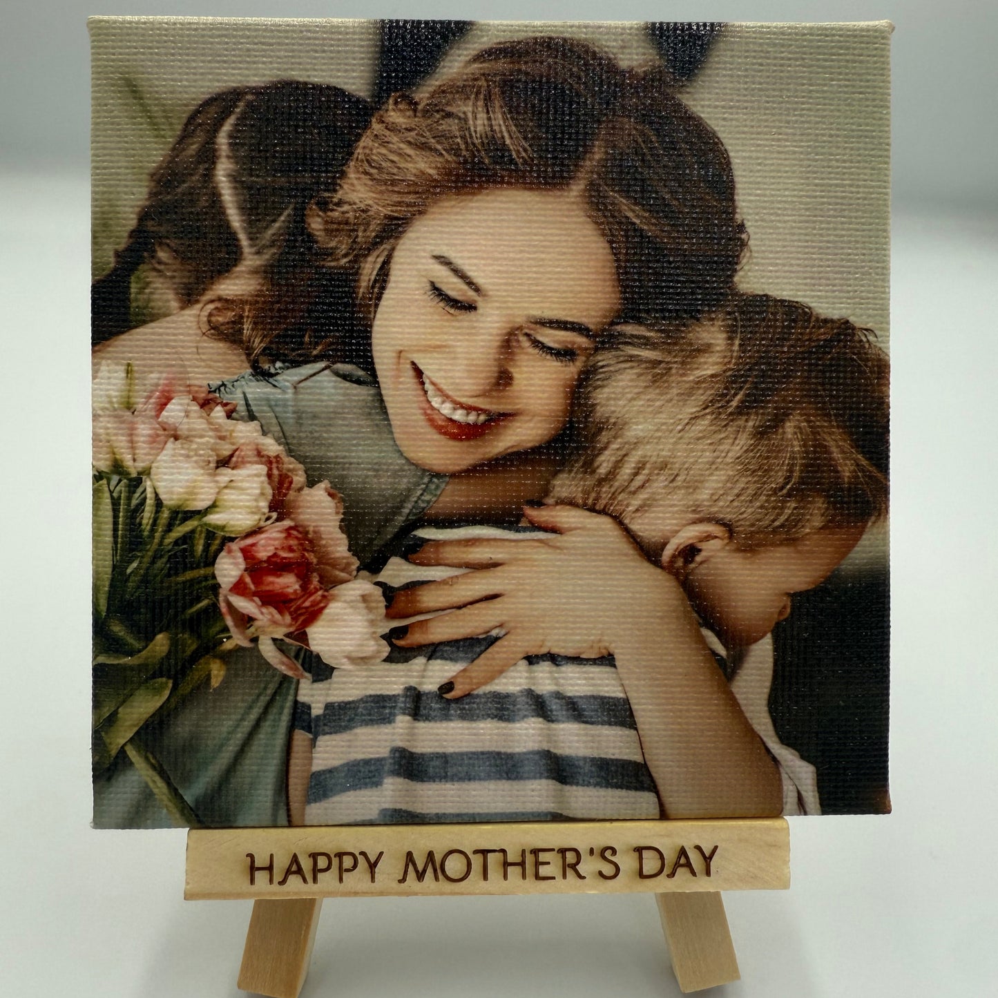 Canvas print of a woman and child with flowers, featuring 'Happy Mother's Day' text.
